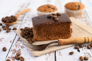 Chocolate cake on the sack and coffee beans with fork on a wooden table.