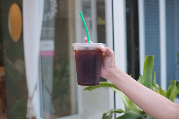 A beautiful ice black coffee served with plastic glass. Selective focus. blur background