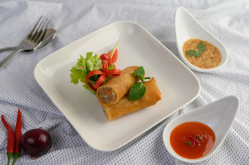 Egg roll or Fried Spring Rolls on the white plate Thai food. Selective focus.