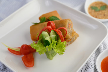 Egg roll or Fried Spring Rolls on the white plate Thai food. Selective focus.