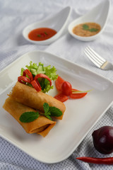 Egg roll or Fried Spring Rolls on the white plate Thai food. Selective focus.