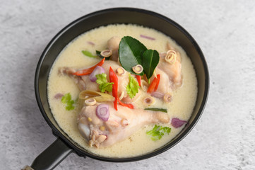 Tom Kha Kai in a pan frying with kaffir lime leaves, lemongrass, red onion, galangal and chilli.
