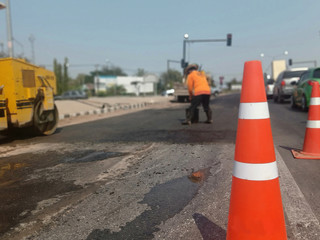 Pictures blurring red rubber cones and road construction workers