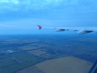flying in a plane in the sky above the clouds on the wing at dawn aviation vacation