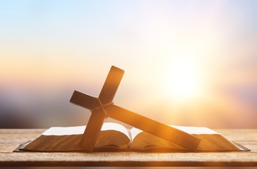 Holy Bible book and cross on a wooden desk