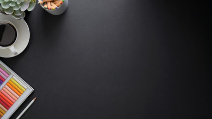 Overhead shot of  workplace with copy space, painting tools and coffee cup on black table