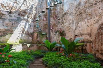 Bonito patio con muñecos, plantas y campanas en Antigua Guatemala. 