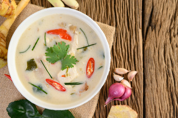 Tom Kha Kai in a bowl with kaffir lime leaves, lemongrass, red onion, galangal and chilli.