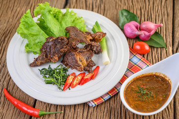 Beef fried Thai food on a white plate with spring onion, kaffir lime leaves, chilies, salad, red onions and tomatoes. Selective focus.