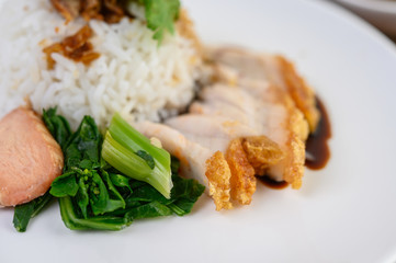 Crispy pork on a white plate topped with sauce.