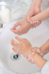 Young asian woman washing hands for her son