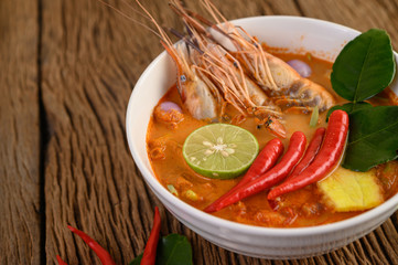 Tom Yum Kung Thai hot spicy soup shrimp with lemon grass,lemon,galangal and chilli on wooden background Thailand Food
