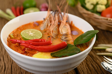 Tom Yum Kung Thai hot spicy soup shrimp with lemon grass,lemon,galangal and chilli on wooden background Thailand Food