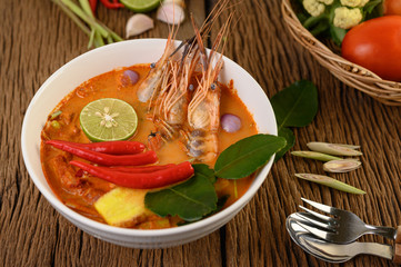 Tom Yum Kung Thai hot spicy soup shrimp with lemon grass,lemon,galangal and chilli on wooden background Thailand Food