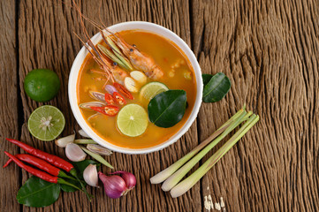 Tom Yum Kung Thai hot spicy soup shrimp with lemon grass,lemon,galangal and chilli on wooden background Thailand Food