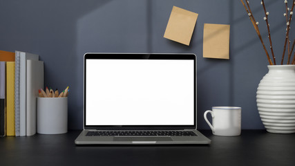 Close up view of trendy workplace with mock up laptop, books and decorations