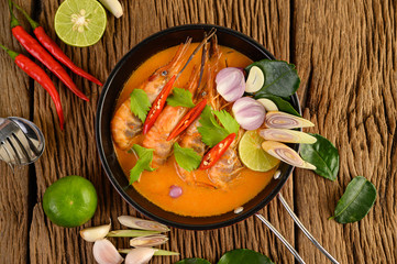 Tom Yum Kung Thai hot spicy soup shrimp with lemon grass,lemon,galangal and chilli on wooden background Thailand Food