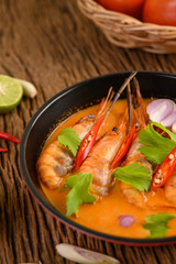 Tom Yum Kung Thai hot spicy soup shrimp with lemon grass,lemon,galangal and chilli on wooden background Thailand Food