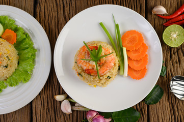 Shrimp fried rice on a white plate on a wooden table
