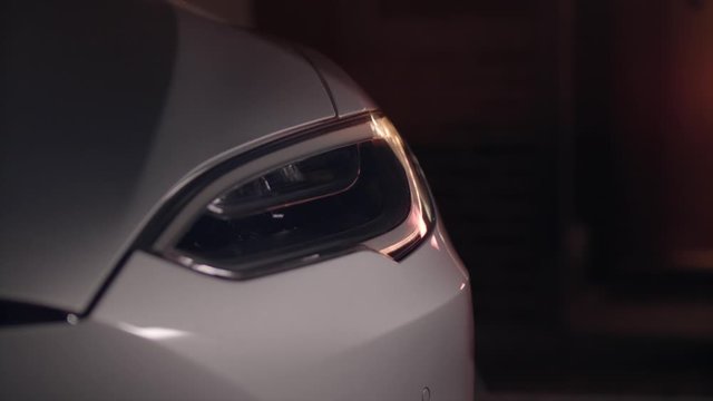 Tesla Model S driver asks around car as lights come on.
