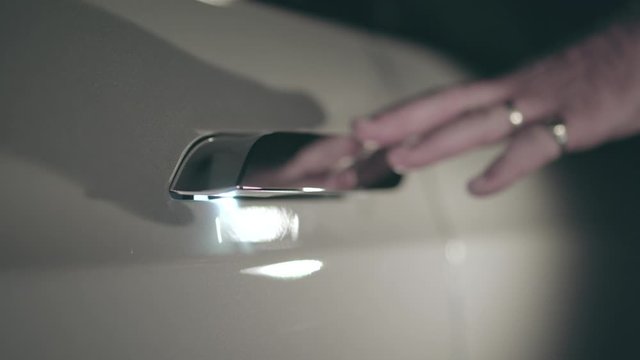 Tesla Model S door handle being touched by mans hand