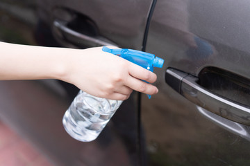 Asian women disinfect and clean the handle of car door