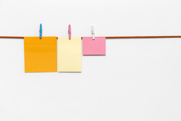 Office clips on leather string isolated. orange sticky notes with cloth pegs. 