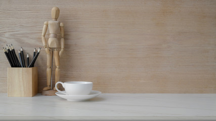 Close up view of workplace with copy space, coffee cup and decorations on marble desk