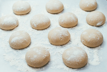 Fototapeta na wymiar Homemade dough pies on the baking sheet ready for the oven for baking