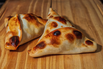 Sfiha, kind of pie like originating in Syria and Lebanon and widely consumed in all the world, on rustic wooden table.