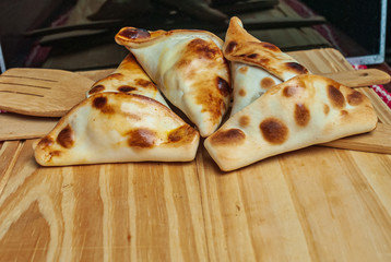 Sfiha, kind of pie like originating in Syria and Lebanon and widely consumed in all the world, on rustic wooden table.