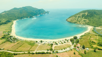 Aerial drone, bird's eye view photo from north of Mawun beach, Lombok Island, Indonesia. White sandy beach, green hills and blue sky. View of another side of mandalika circuit in Lombok. Background.