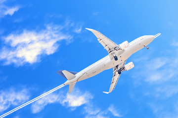 A white passenger plane that has just taken off on a  background of the trace left by military aircraft