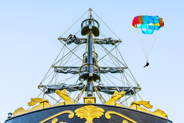 Pirate ship and parachutist on a multi-colored parachute on background