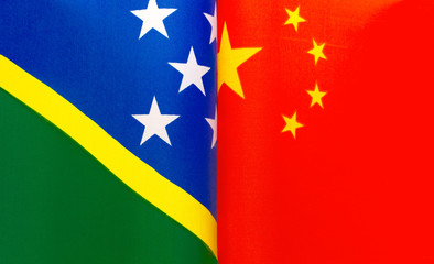 fragments of the national flags of the Solomon Islands and China in close-up