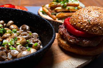 concept fat food. unhealthy food burger and fried mushrooms