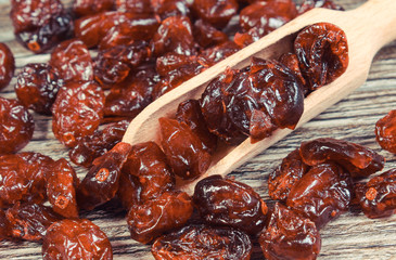 Cranberries with spoon as source minerals and fiber. Wooden background