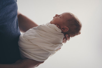 Newborn baby lying on hands of parents. Imitation of baby in womb. beautiful little girl sleeping...