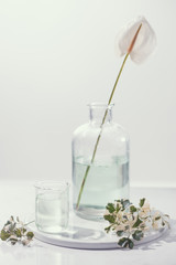 Perfume oils concept. Laboratory glassware with infused floral water on table