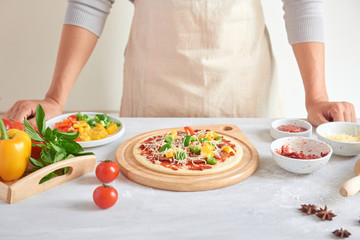 Obraz na płótnie Canvas Raw pizza with ingredients in the background
