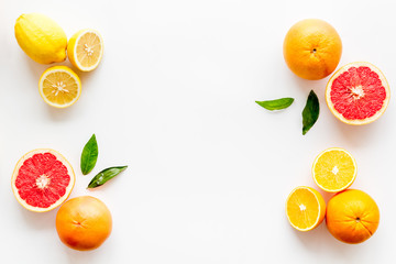 Citrus pattern. Cut lemon and grapefruits and leaves on white background top-down copy space