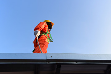 Worker in safety harness on high construction site .