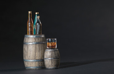 Liquor Bottles on Wooden Wine Barrel with a Dark Background