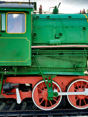 Green old soviet steam locomotive on the rails