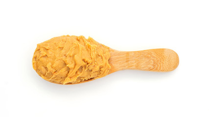 Peanut butter in a spoon on a white background.
