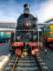 Image of old black steam locomotive at railroad station