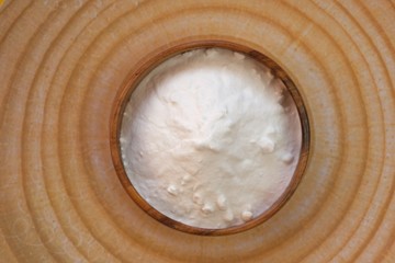Baking soda. Sodium bicarbonate  in a wooden round cup on a wooden  background.