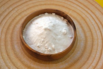 Fototapeta na wymiar Baking soda. Sodium bicarbonate in a wooden round cup on a wooden round dish .