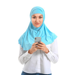 Young Arab woman with mobile phone on white background