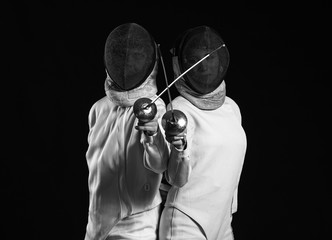 Young fencers on dark background